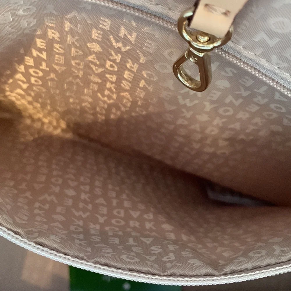 Kate Spade cream colored cloth tote with green leaf pattern.